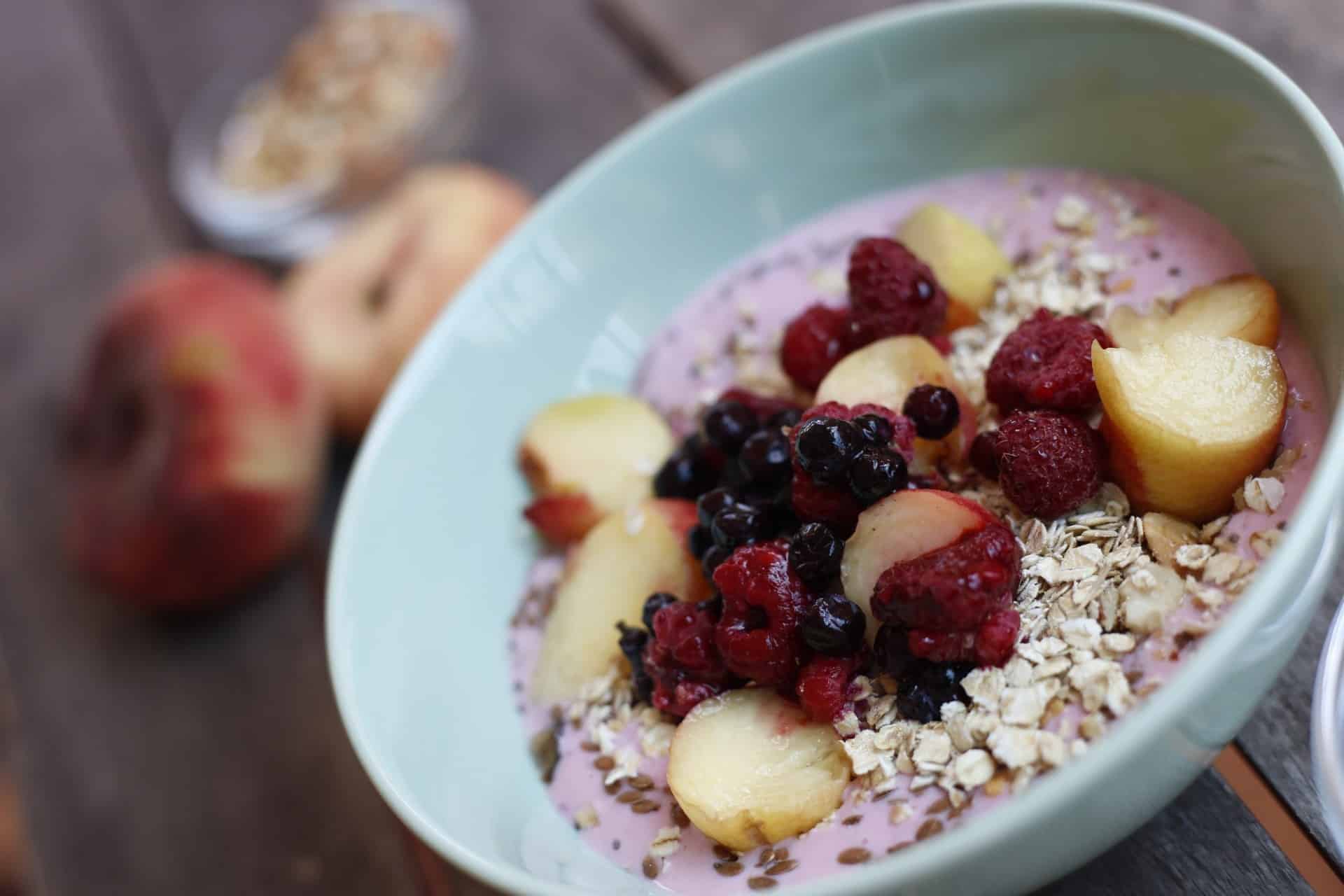 Acai Bowl mit Beeren und Pfirsichen zum Frühstück