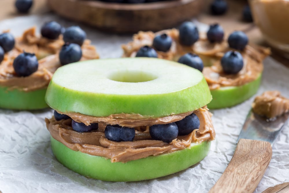 Apfel Snack mit Erdnussbutter und Heidelbeeren