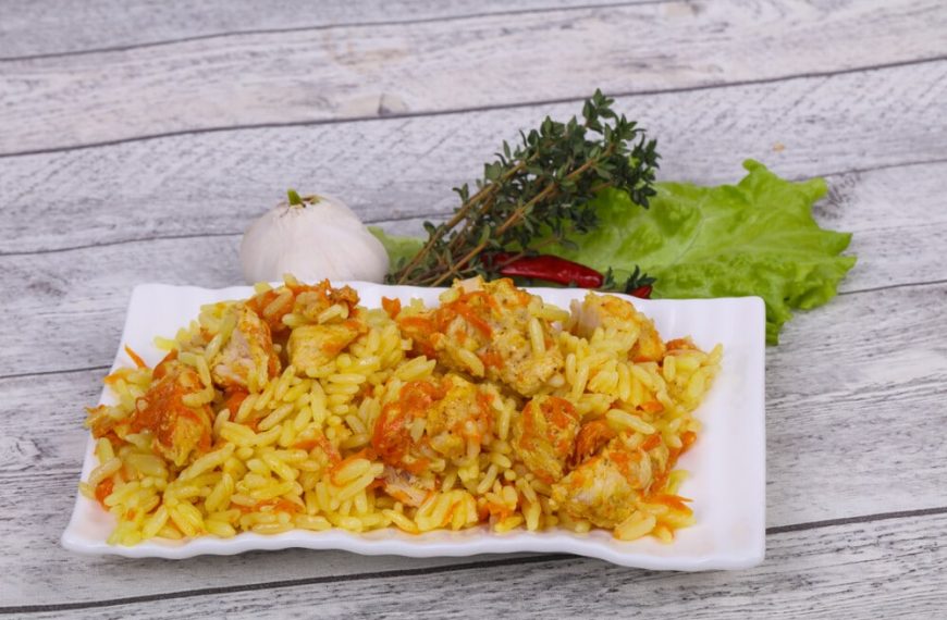 Asiatischer Pilaw mit Reis, Hähnchen, Karotten und Zwiebeln
