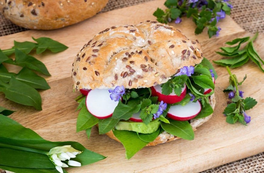 Belegte Brötchen mit Avocado, Bärlauch und essbaren Blüten zum Frühstück
