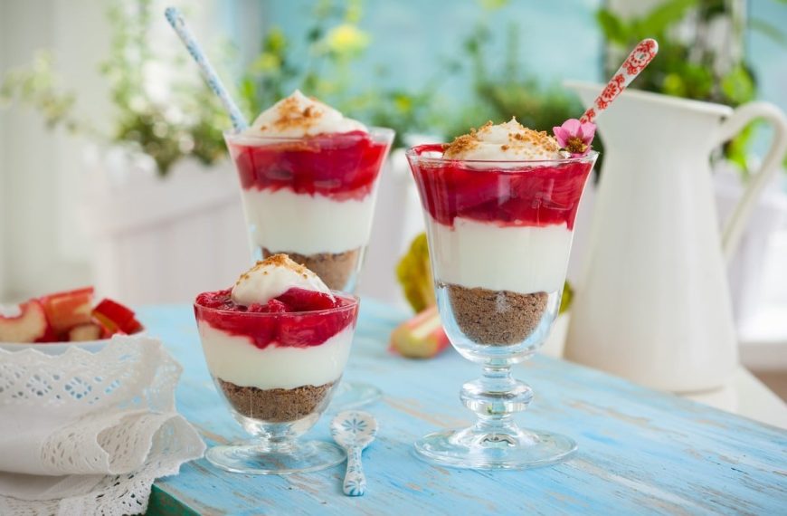 Cheesecake Dessert im Glas mit Erdbeeren und Rhabarber