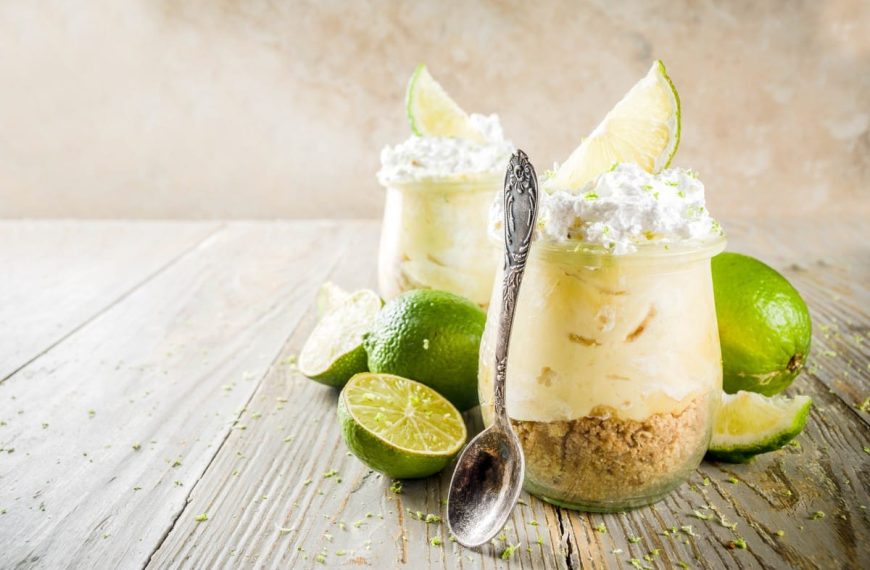 Cheesecake Dessert mit Butterkeksen, Limetten und Frischkäse im Glas