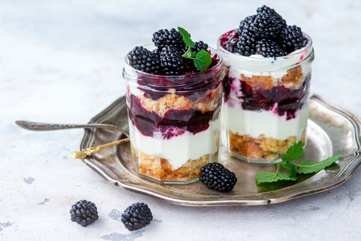 Cheesecake Nachspeise im Glas mit Joghurt und Brombeeren