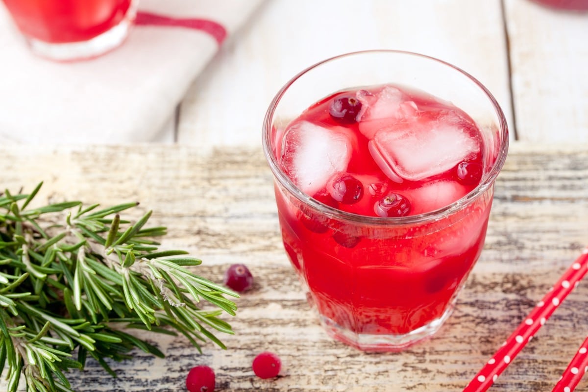 Cocktail Whisky Sour mit Cranberrysirup und Zitrussaft