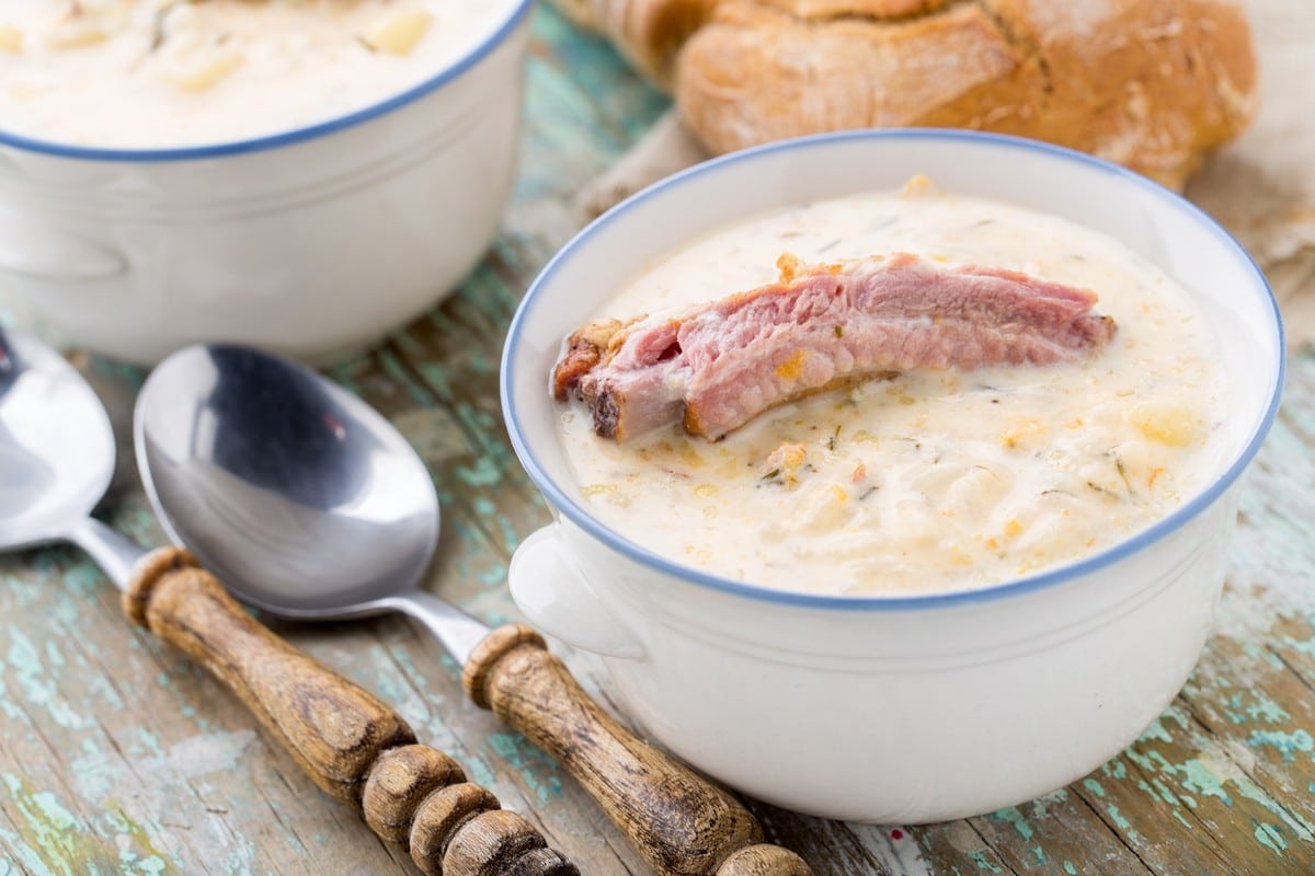 Cremige Käsesuppe mit Gemüse, geräuchertem Fleisch und Schmelzkäse