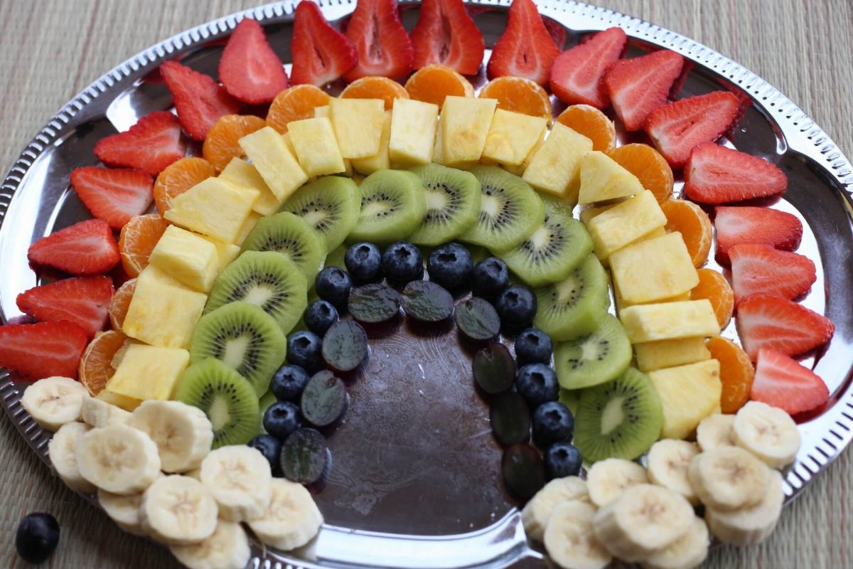 Fingerfood Obstsalat als Regenbogen mit Erdbeeren und Bananen