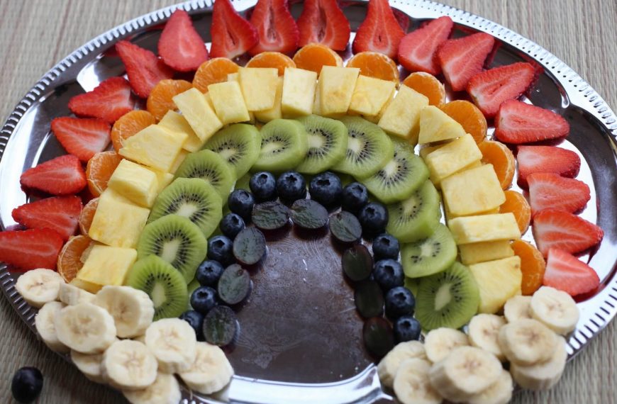Fingerfood Obstsalat als Regenbogen mit Erdbeeren und Bananen