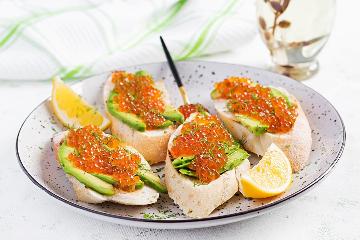 Fingerfood mit Avocado und rotem Kaviar auf Baguette