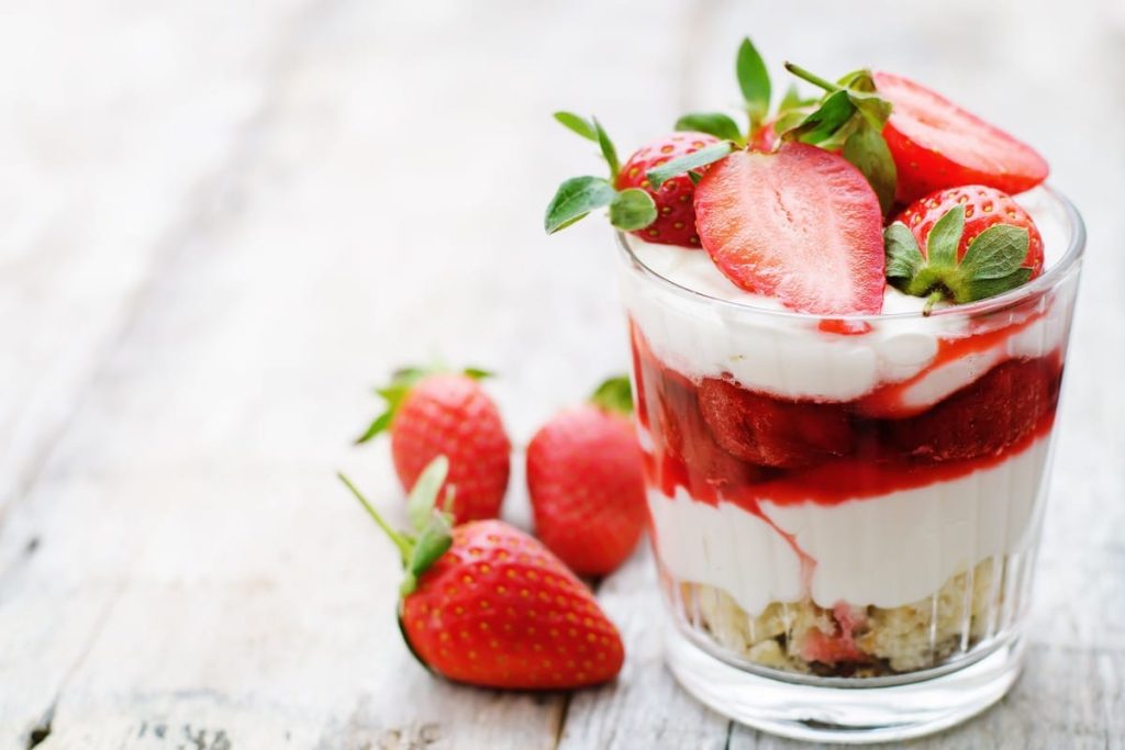 Fruchtiges Schichtdessert im Glas mit Erdbeeren und Eiscreme