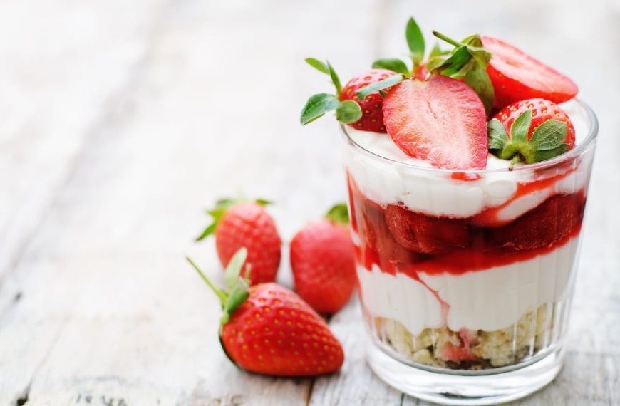 Fruchtiges Schichtdessert im Glas mit Erdbeeren und Eiscreme