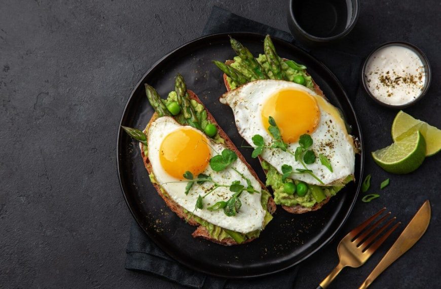 Frühstücksei auf Avocado Brot mit grünem Spargel