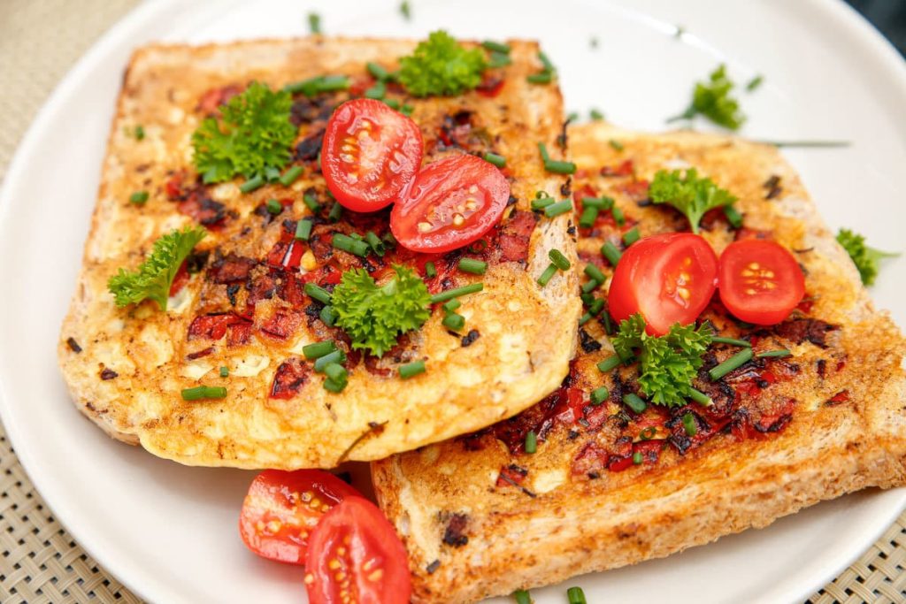 Frühstücksei im Toast mit Käse, Salami und Paprika