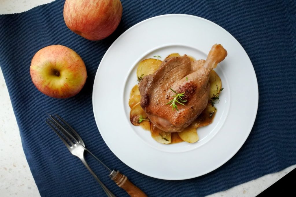 Gebackene Entenkeulen mit Äpfeln und Knoblauch im Backofen