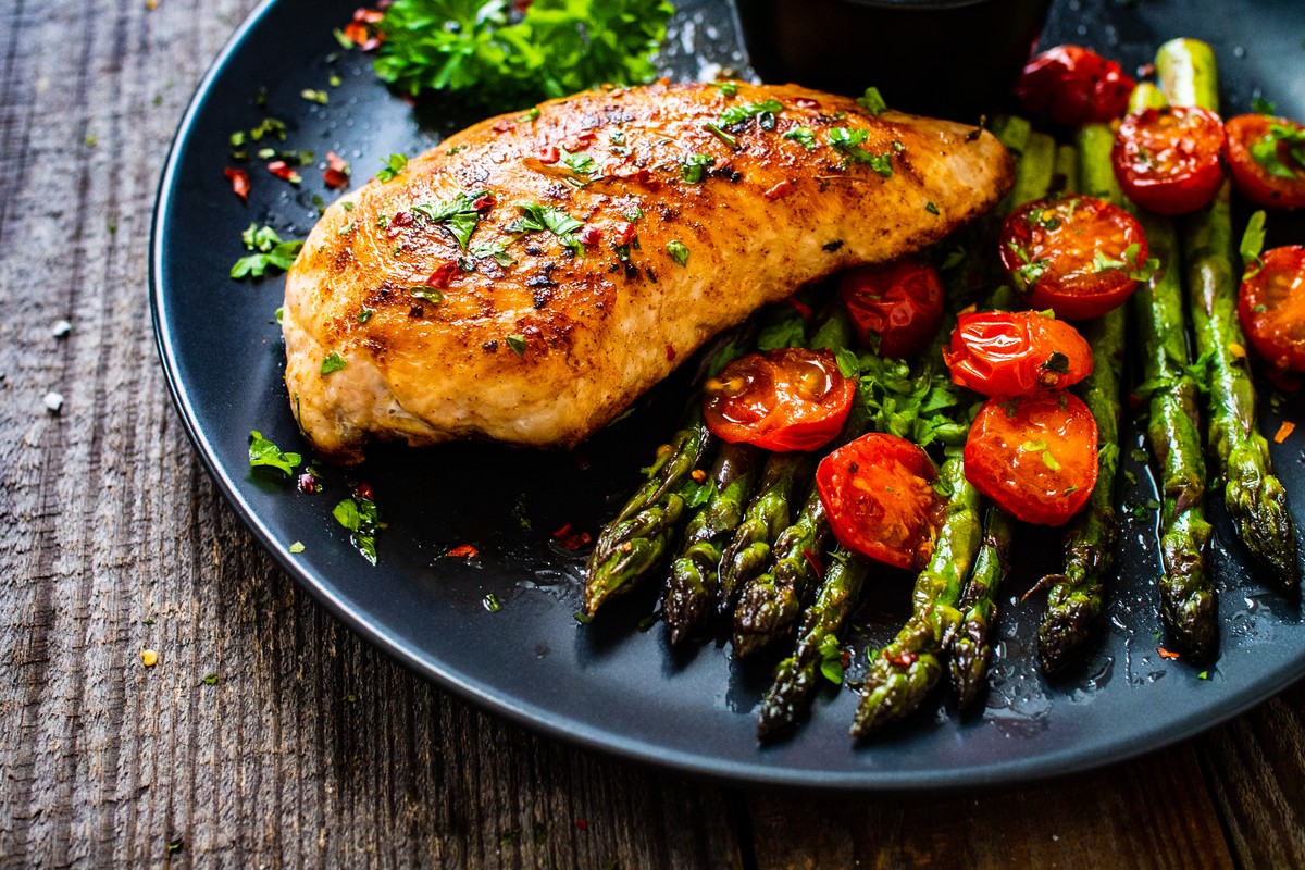 Gegrillte Hähnchenbrustfilets mit grünem Spargel und Tomaten