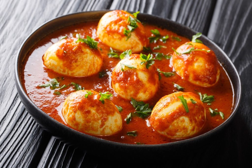 Gekochte Eier in Tomatensauce mit Gewürzen und Knoblauch