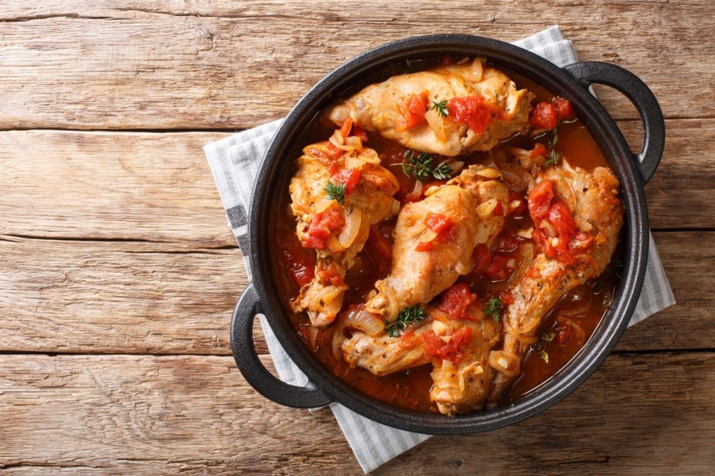 Geschmortes Kaninchen mit Zwiebeln in Tomaten Weinsoße