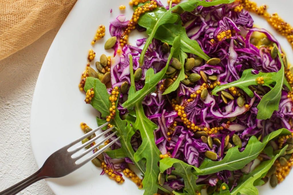Gesunder Rotkohlsalat und Rucola und Kürbiskernen