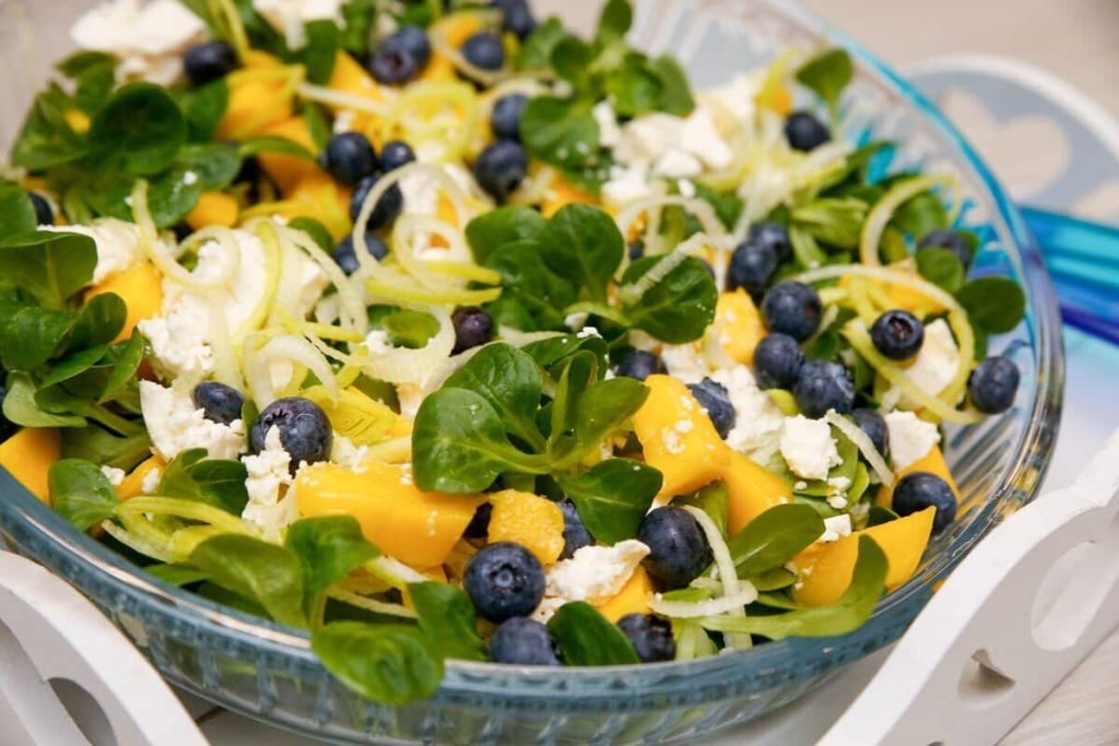 Grüner Salat aus Feldsalat mit Mango und Heidelbeeren