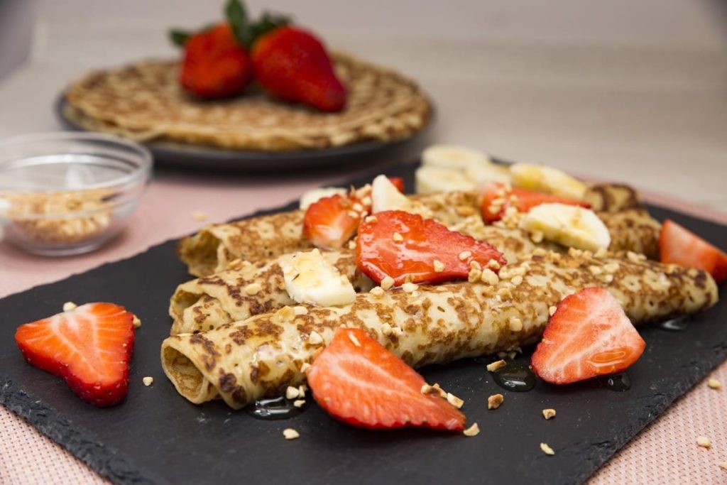 Hefepfannkuchen mit Erdbeeren, Bananen und Nüssen