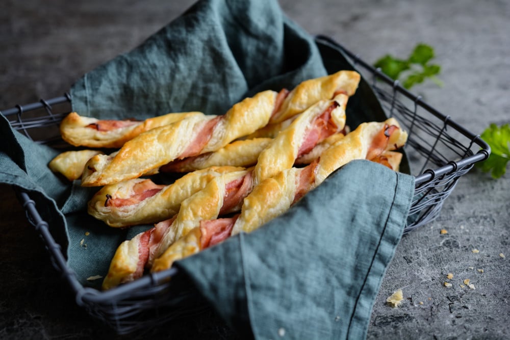 Herzhafte Blätterteigstangen mit Speck im Ofen überbacken