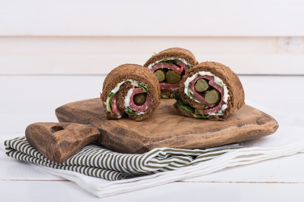 Herzhafte Röllchen Snacks mit Schwarzbrot und Wurst