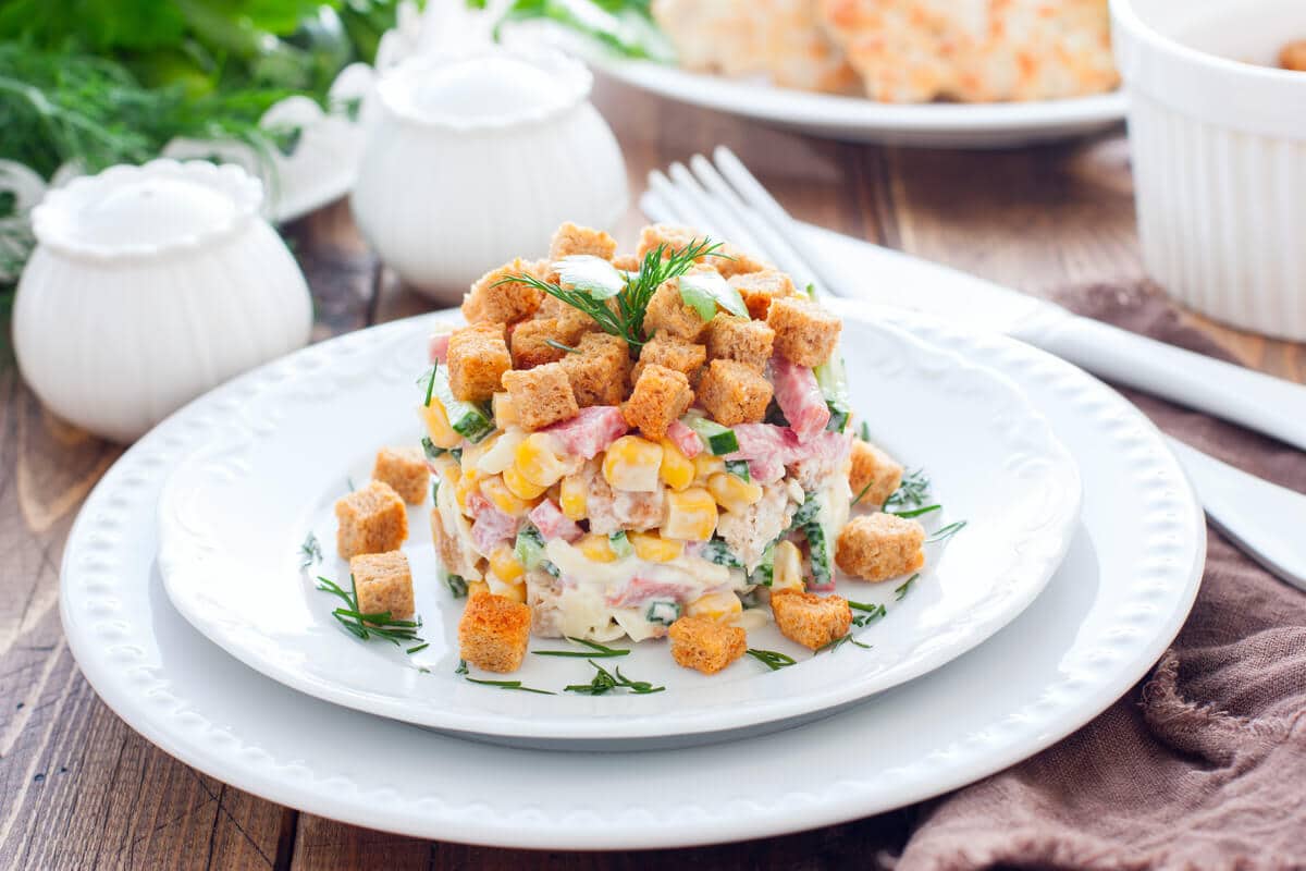 Herzhafter Gemüsesalat mit Mais, Wurst und Croutons