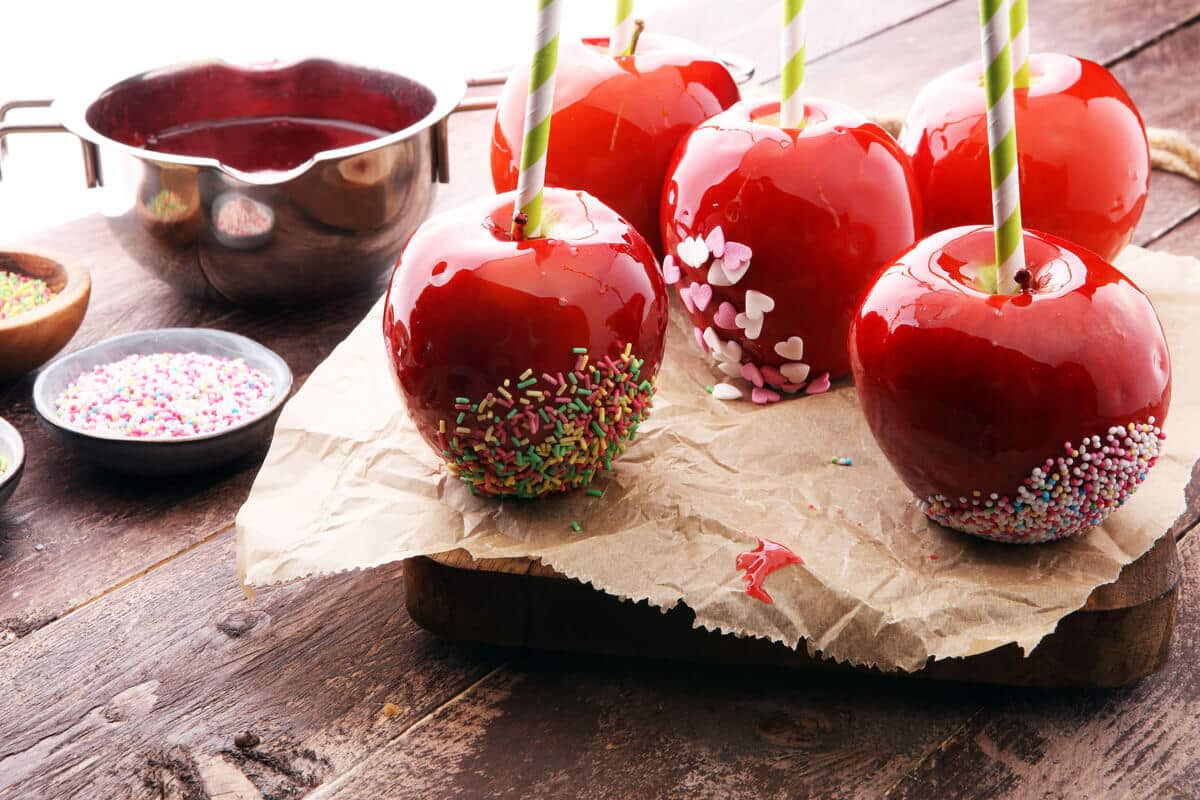 Kandierte rote Äpfel im Zuckersirup mit Zuckerstreuseln