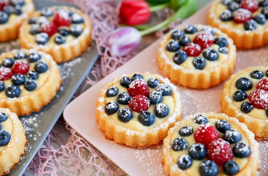 Kleine Obsttörtchen aus Biskuit mit Beeren und Pudding