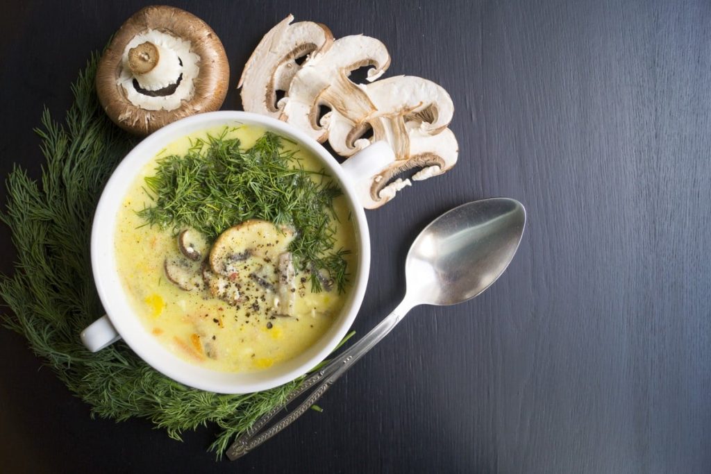 Köstliche Käsesuppe mit Gemüse und frischen Champignons
