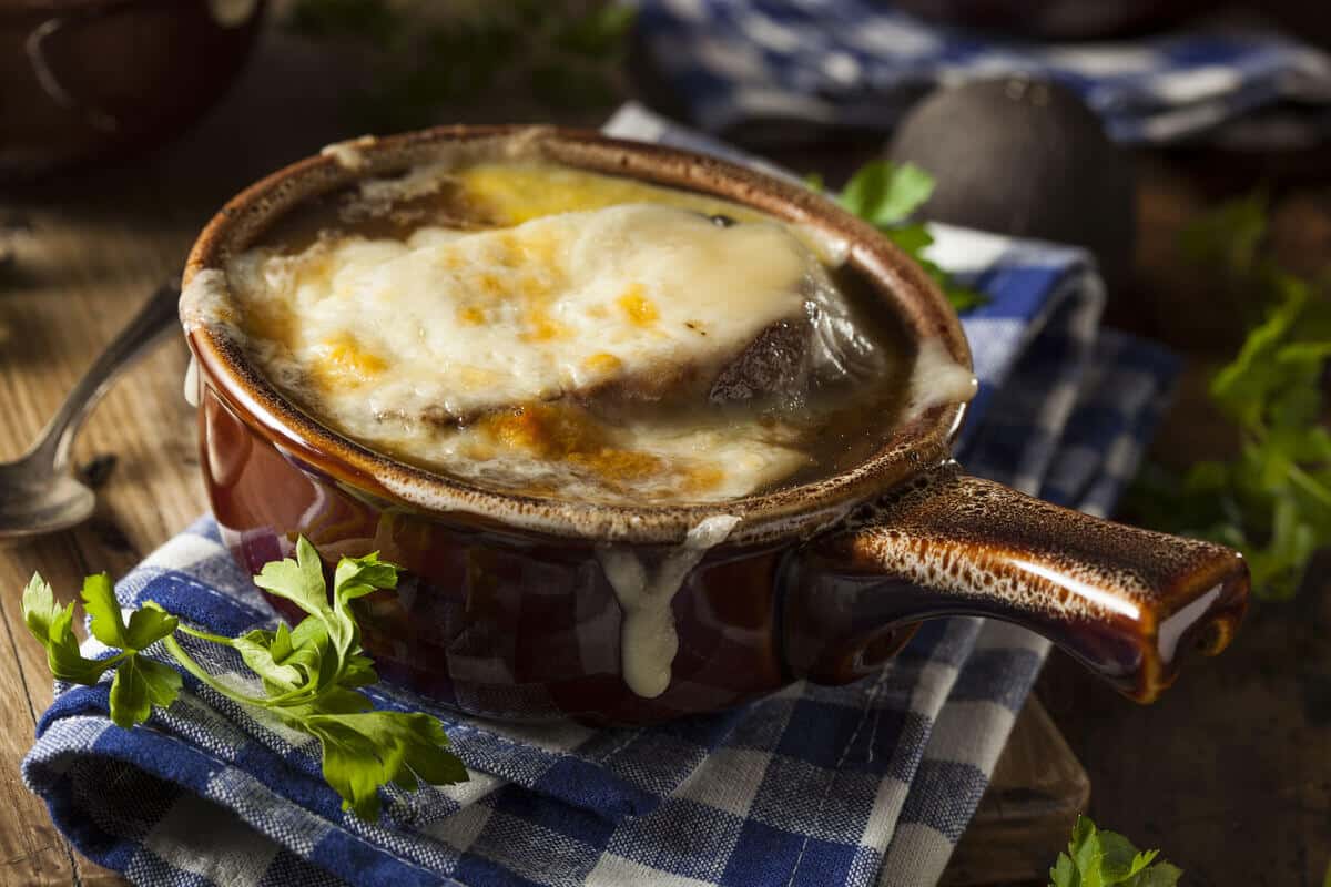 Köstliche Zwiebelsuppe mit Bier und Käse-Brot-Kruste im Ofen überbacken