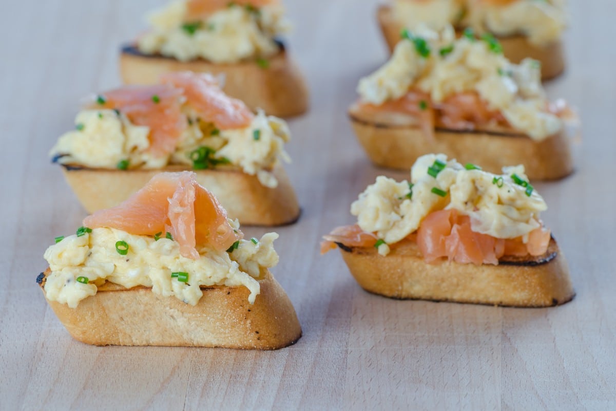 Leckere Bruschetta mit Rührei, Lachs und Schnittlauch zum Frühstück