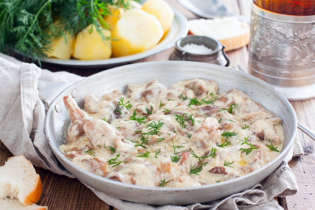 Leckere Pilze mit gebratenen Zwiebeln in Schmandsoße