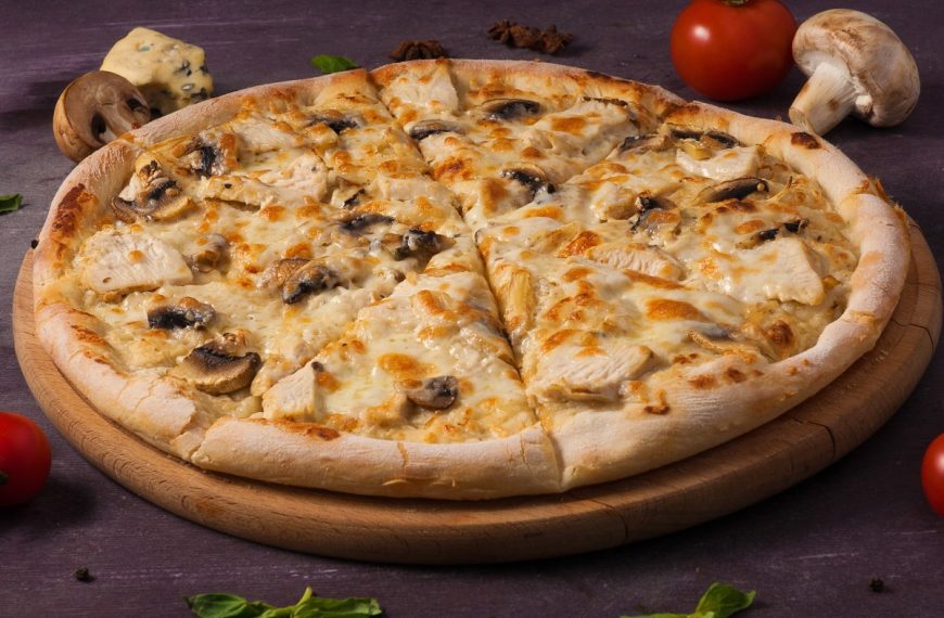 Leckere Pizza mit Hähnchen und Champignons