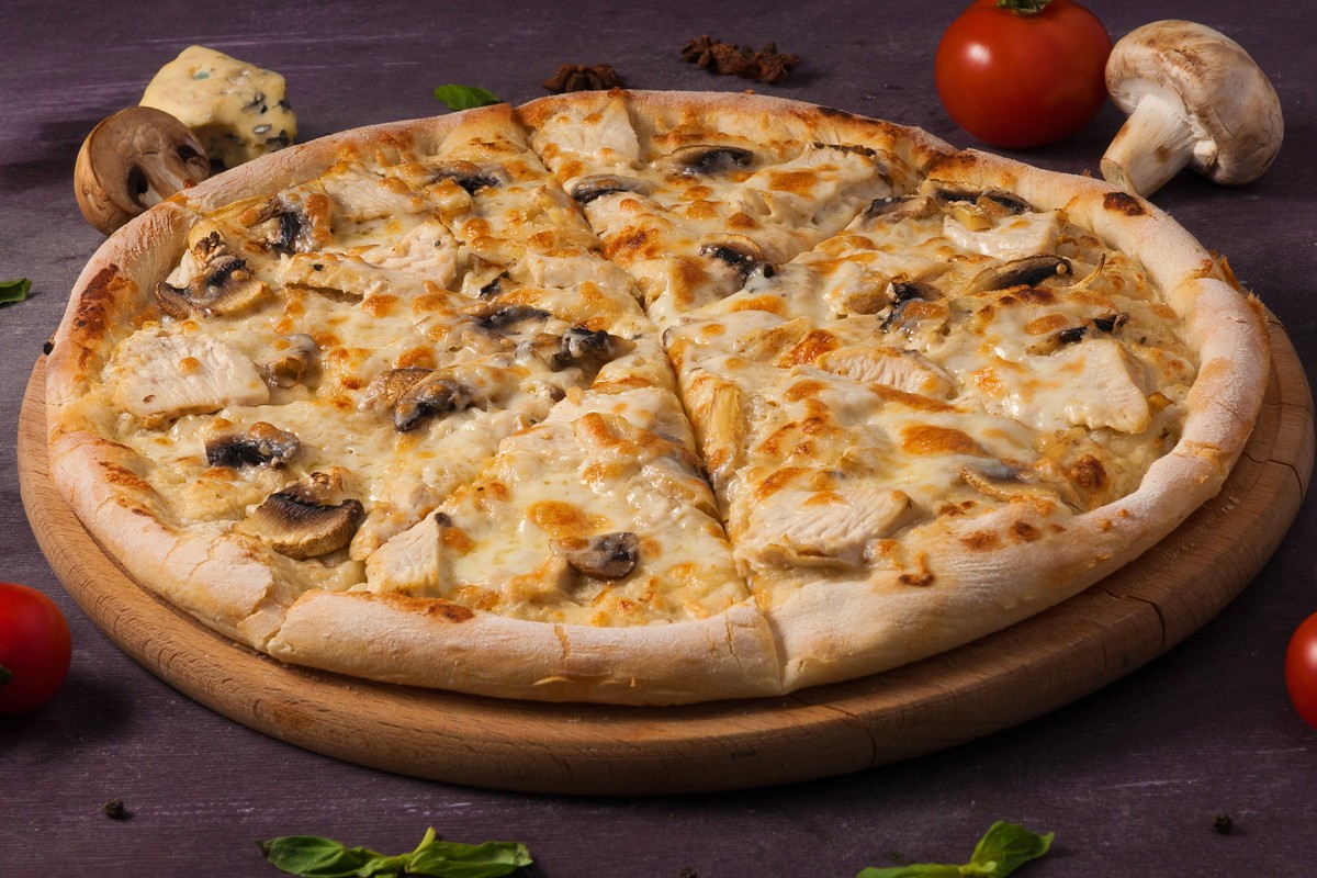 Leckere Pizza mit Hähnchen und Champignons