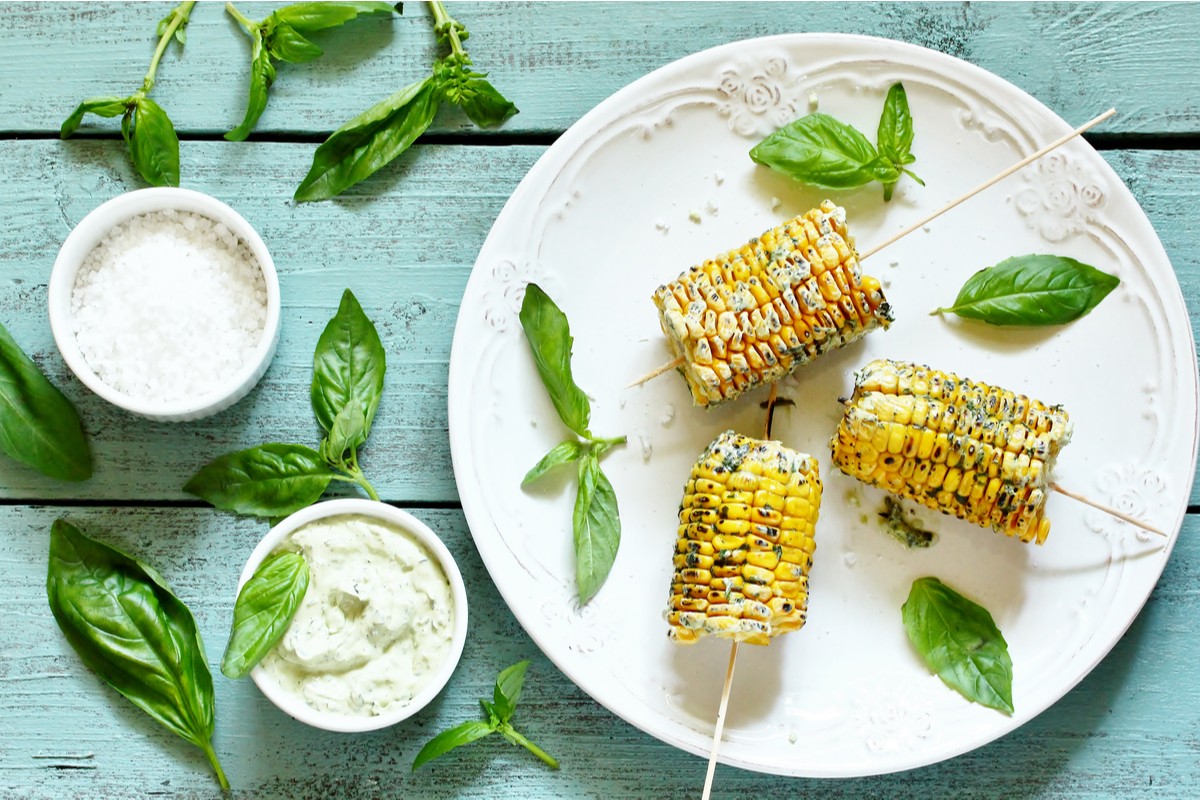 Maiskolben mit Parmesan und Kräuteröl auf dem Grill