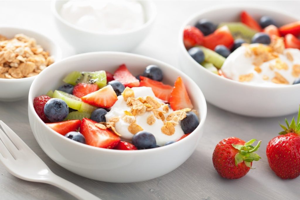 Obstsalat aus Erdbeeren, Kiwi und Blaubeeren mit Granola und Joghurt