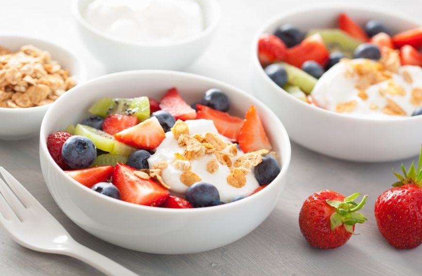 Obstsalat aus Erdbeeren, Kiwi und Blaubeeren mit Granola und Joghurt