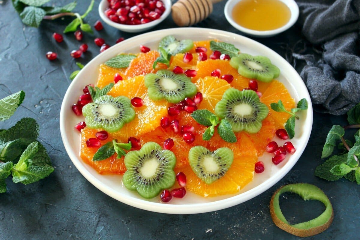 Obstsalat mit Orangen, Kiwis, Granatapfel und Honigdressing