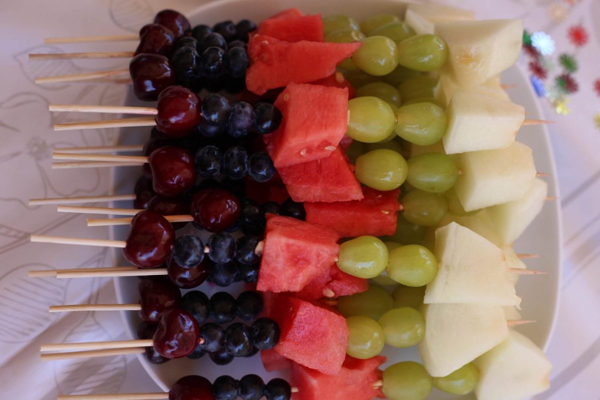 Sommersnack Obstspieße mit Erdbeeren, Ananas, Bananen und Trauben