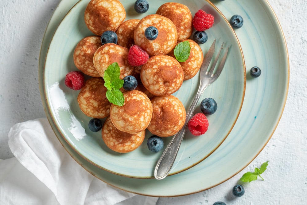 Poffertjes Mini Pfannkuchen mit Puderzucker und Beeren