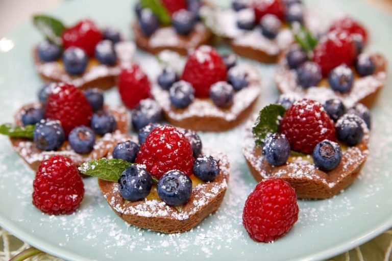 Kleine Obsttörtchen aus Biskuit mit Beeren und Pudding