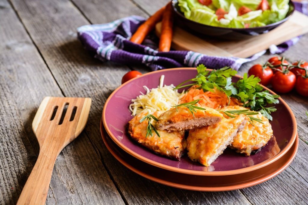 Überbackene Schweineschnitzel mit Zwiebeln und Käse