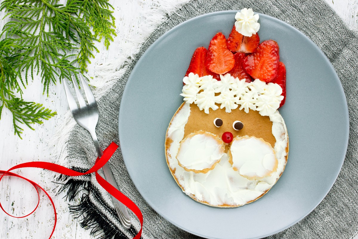 Weihnachtsfrühstück mit Weihnachtsmann aus Pancakes und Erdbeeren
