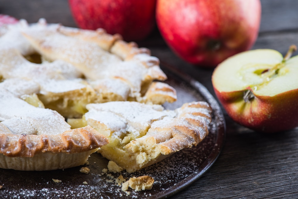 Gedeckter Apfelkuchen mit Zimt zum Kaffee