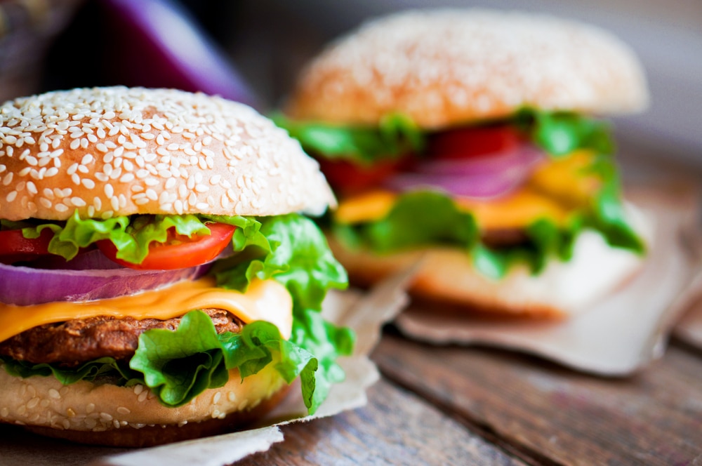 Gegrillte Hamburger mit Tomaten, Salat und Cheddar-Käse