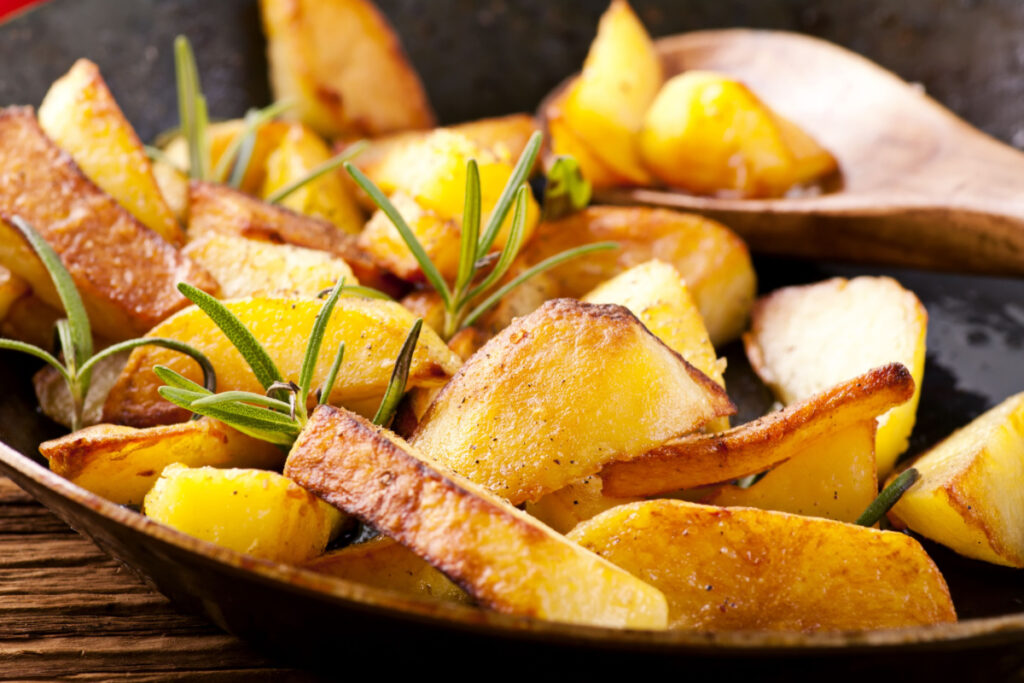 Goldbraune Bratkartoffeln mit Zwiebeln und Rosmarin