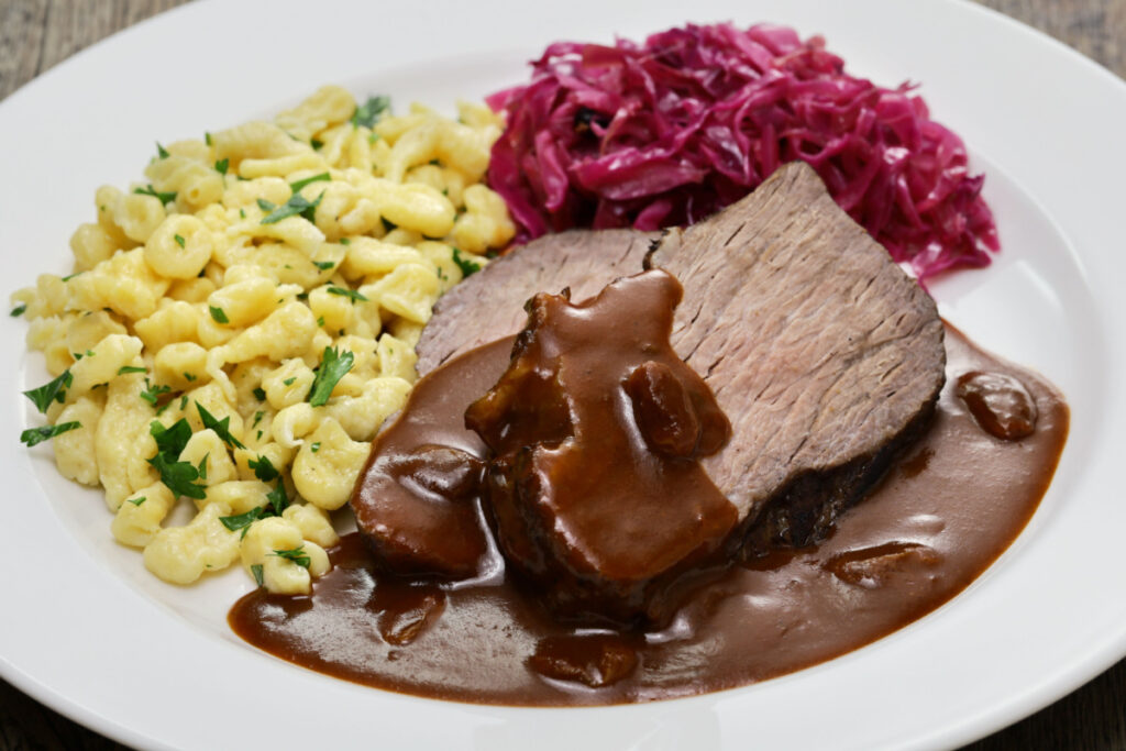 Herzhafter Sauerbraten mit Soße, Spätzle und Rotkohl